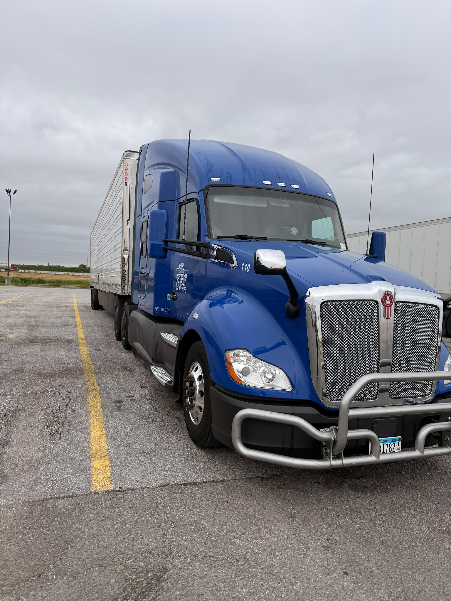 A modern blue semi-truck and white trailer parked outdoors, showcasing reliable owner-operator dispatching and time-sensitive cargo transportation.